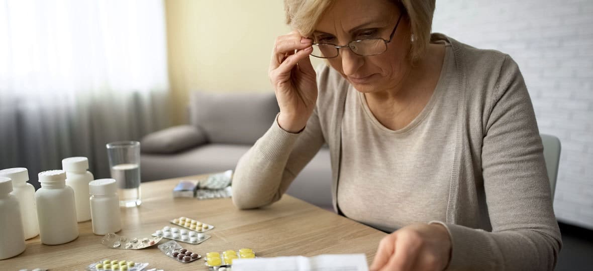 Elderly women struggling to organize her pills.